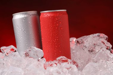 Koyu kırmızı arka planda buzlu içeceklerin tazelenmesi, yakın plan