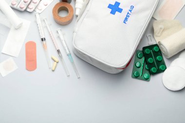 Gri arkaplan üzerinde ilk yardım çantasıyla düz konum, metin için boşluk
