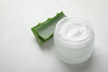 Beyaz desenli arkaplanda krema ve aloe yaprakları