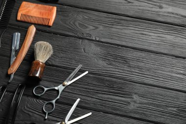 Siyah ahşap masa üzerinde birçok farklı berber aletleri, düz yatıyordu. Metin için boşluk
