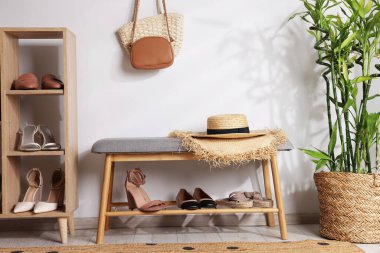 Farklı şık ayakkabılar, hasır şapkalar, çantalar ve ev bitkileriyle duruyor.