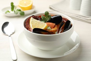 Hafif ahşap masada servis edilen lezzetli deniz ürünleri çorbası, yakın plan.