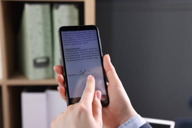 Elektronik imza. İçerde akıllı telefon kullanan kadın, yakın plan.