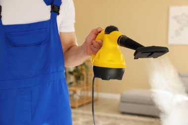 Evde buhar temizleyicisi olan kapıcı, yakın çekim.