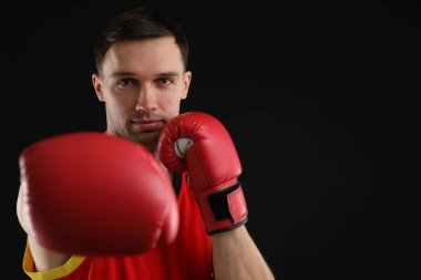 Siyah arka planda dövüşen boks eldivenli adam, metin için boşluk