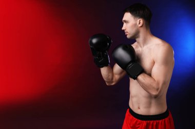 Siyah arka planda boks eldivenli bir adam neon ışıklarda, metin için boşluk