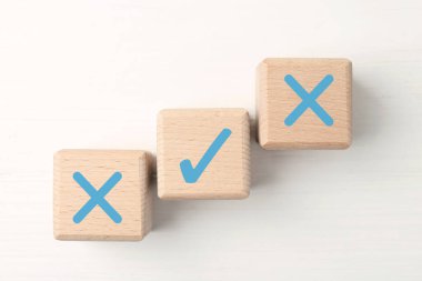 Reddedilmeyi onayla. Beyaz arka planda işaretli tahta küpler, üst görünümde çapraz işaretler