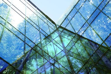 Modern bina ve bereketli ağaçlar, mavi gökyüzüne karşı, çift pozlama. Düşük açı görünümü