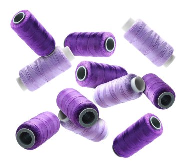 Birçok dikiş iplikleri mor rengin farklı tonlarında beyaz arkaplanda uçuyor.