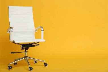 Sarı arka planda modern ofis koltuğu. Metin için boşluk