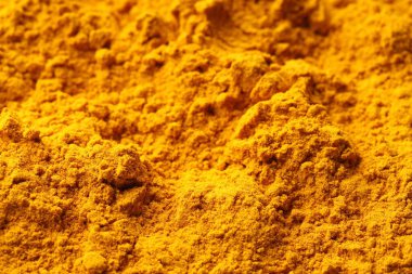 Aromatic turmeric powder as background, closeup view