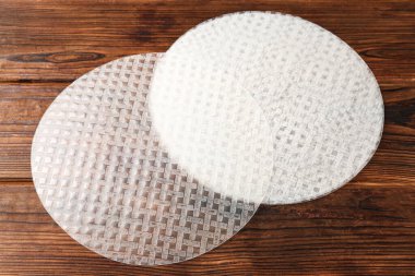 Edible rice paper sheets on wooden table, closeup