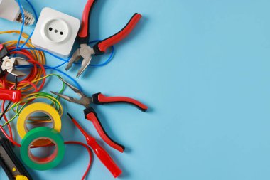 Açık mavi arka planda, düz zeminde farklı elektrikli aletler. Metin için boşluk