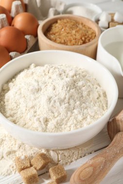 Hamur için merdane ve malzemeler beyaz ahşap masada, yakın plan.