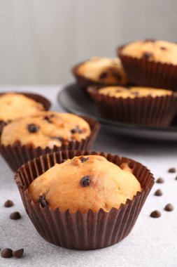 Açık gri masada çikolata parçalı lezzetli kek, yakın plan.