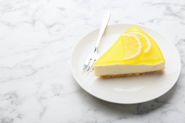 Lezzetli limonlu cheesecake ve çatal beyaz mermer masa, yakın plan. Metin için boşluk