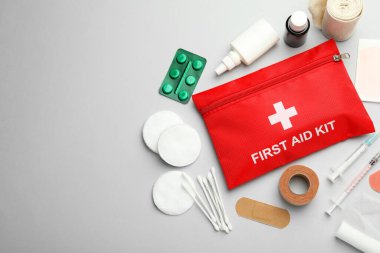 Gri arkaplan üzerinde ilk yardım çantasıyla düz konum, metin için boşluk