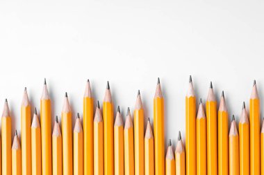 Açık gri arka planda bir sürü kalem, üst manzara. Metin için boşluk