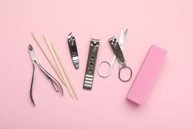 Pembe arka planda farklı manikür araçları, düz yatış