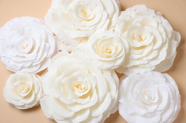 Bej arka planda güzel beyaz kağıt çiçekler, düz uzanmış