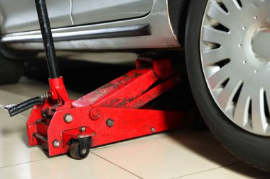 Benzin istasyonunda makas krikoyla kaldırılan araba, yakın plan.