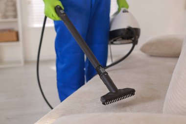 Profesyonel temizlikçi kanepede buhar sistemi var, yakın çekim.