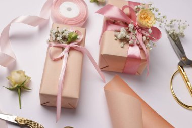 Çiçekçi. Beyaz arkaplanda kutular, çiçekler, makas ve kurdele