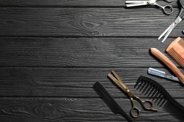 Siyah ahşap masa üzerinde birçok farklı berber aletleri, düz yatıyordu. Metin için boşluk