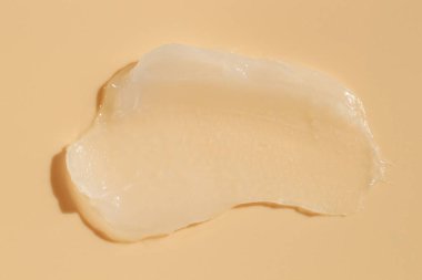 Bej arka planda nemlendirici dudak kremi, üst görünüm