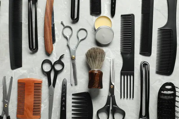 Açık gri masa üzerinde birçok farklı berber aletleri, düz yatıyordu