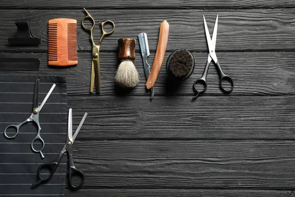 Siyah ahşap masa üzerinde birçok farklı berber aletleri, düz yatıyordu. Metin için boşluk