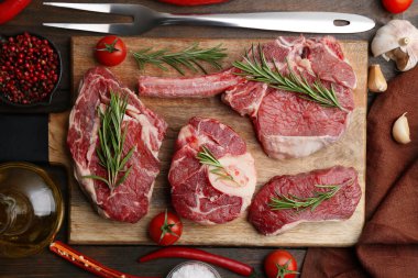 Çiğ et parçaları, baharatlar ve ürünler ahşap masa üzerinde, düz yatıyordu.
