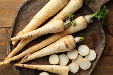 Taze maydanoz kökleri ahşap masada, üst tarafta.