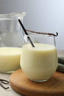 Gri masadaki lezzetli vanilyalı süt ve kapsüller