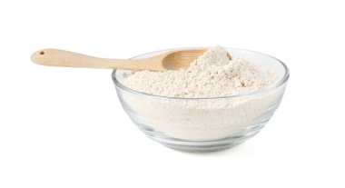 Kahverengi pirinç unu ve kaşık beyaz kasede izole edilmiş.