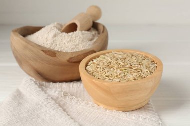 Kahverengi pirinç ve un beyaz ahşap masada, yakın plan.