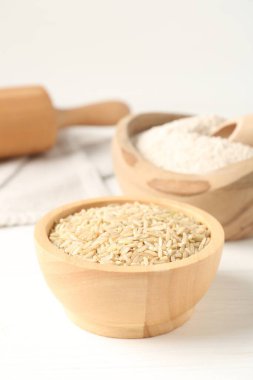 Kahverengi pirinç ve un beyaz ahşap masada, yakın plan.
