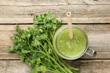 Sağlıklı maydanozlu meşrubat kavanozunda Tahta masada yapraklar