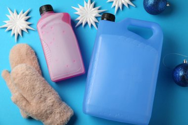 Açık mavi arka planda antifriz, eldivenler ve kış dekoru, düz yatıyordu.