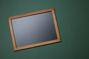 Yeşil arkaplanda boş küçük karatahta, üst görünüm