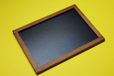 Sarı arkaplanda boş küçük bir tahta.