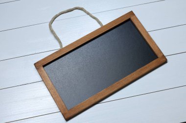 Beyaz ahşap zemin üzerinde boş küçük karatahta, üst görünüm