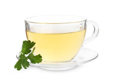 Cam fincanda aromatik bitki çayı ve beyaz arka planda taze maydanoz.