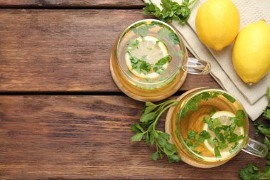 Tahta masa üzerinde limon dilimleri olan sağlıklı maydanoz çayı, düz yatak ve yazı için yer. Detoks içeceği