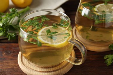 Tahta masada limon dilimleri olan sağlıklı maydanoz çayı, yakın plan. Detoks içeceği