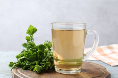 Gri ahşap masada sağlıklı maydanoz çayı, yakın plan. Detoks içeceği