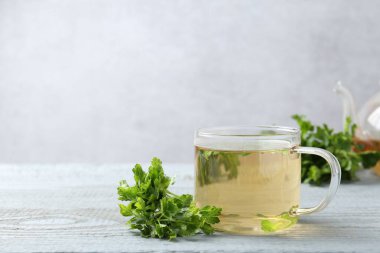 Sağlıklı maydanoz çayı gri ahşap masada, yazı için yer var. Detoks içeceği