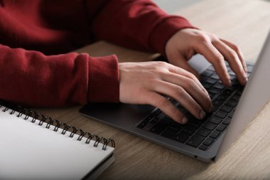 İçerideki masada dizüstü bilgisayar kullanarak internetten öğrenen adam, yakın plan. Kendi kendine çalışma.