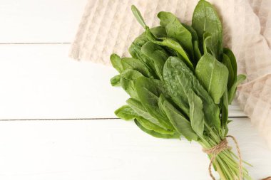 Beyaz ahşap masada taze yeşil defne yaprakları, üst manzara. Metin için boşluk