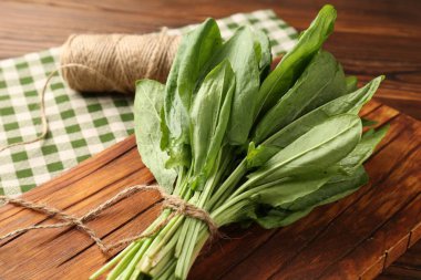 Bir demet taze yeşil kuş yaprağı ve ahşap masa üzerinde sicim, yakın plan